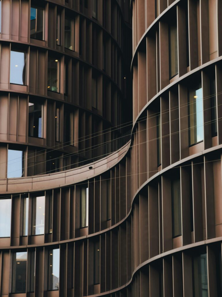 Close-up view of modern curved building architecture with glass windows.